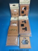 A box of upopened electrical switches and sockets in natural wood effect