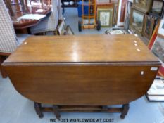 An oak drop-leaf dining table with barley twist legs (Size when open 136cm x 107cm,