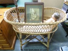 A vintage wicker crib on stand together with a pair of prints, oak lamp,