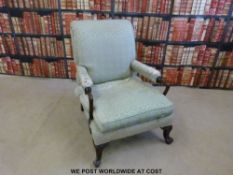 A Georgian style armchair with sweeping upholstered and mahogany arms,
