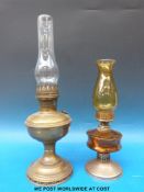 Two brass oil lamps one with amber coloured glass