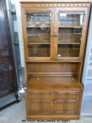 An Ercol dresser with glazed display cabinet to top,