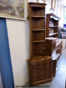 An Ercol corner cupboard with single door together with a plate rack top