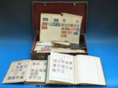 A leather suitcase containing three albums of mainly Victorian stamps together with a large