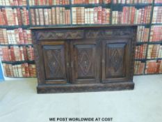 A carved oak sideboard with two drawers above two cupboards (W153 x D47 x H98cm)