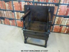 An antique oak metamorphic monk's chair / table with lockable compartment to seat and drawer below