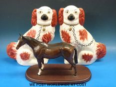 A Beswick horse and two Staffordshire spaniels