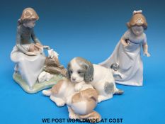 A collection of three Nao figures to include two spaniel puppies,