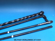 Four African walking sticks one inlaid with mother of pearl, one carved to depict an African man,