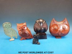 A cast metal owl bookend together with two carved wooden owls,