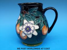 A Moorcroft jug decorated with passion flowers and fruit (15.