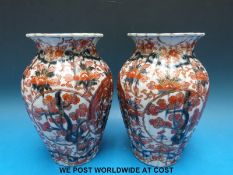 A pair of Japanese vases of ribbed bulbous form with flared rims decorated in Imari colours,