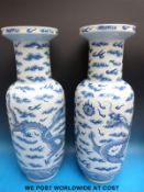 A pair of 19thC Chinese blue and white rouleau vases decorated with dragons amongst stylized clouds