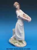 A Lladro figure of a girl with basket of flowers (25cm tall)