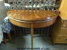 A reproduction fold over games table wityh inlaid and veneered decoration to top (diameter 105