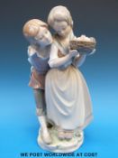 A Lladro boy and girl with a basket of fruit