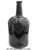 An 18thC 'black' glass mallet shaped wine bottle with seal,