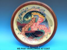A large, wood framed Moorcroft charger decorated with carp,