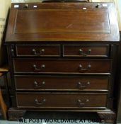 A mahogany bureau, the fall flap opening to reveal pigeon holes, drawers and secret compartments,