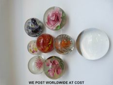 Ten various glass paperweights some with flowers and one with millefiori canes on latticino bed