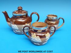 Doulton Lambeth miniature tea set with hallmarked silver rims, the tea pot impressed RN W 810,