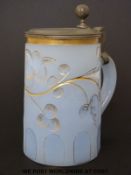 An opaline glass tankard with incised gilt decoration and pewter mounts (16cm tall)