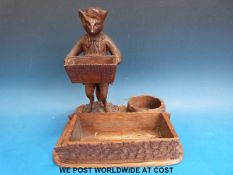 A possibly Black Forest carved wooden desk tidy with a fox holding a basket (height 21cm)