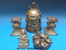A pair of brass oriental stands or candlesticks, brass bell,