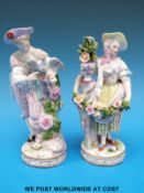 A pair of Meissen figures, one of a lady holding a garland of flowers,