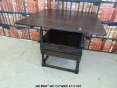 An antique oak metamorphic monk's chair / table with lockable compartment to seat and drawer below