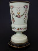 An opaline glass vase decorated in enamels with butterflies amongst floral swags on pedestal base