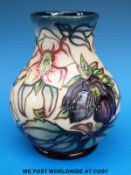 A Moorcroft bulbous pedestal vase decorated with hellebores, 1999 date cipher to base (15.