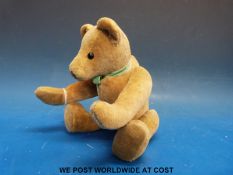 A straw filled teddy bear, possibly Steiff, with cocked hands and wrists, hump back,