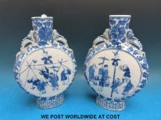 A pair of 19th/20thC Chinese blue and white moon flasks decorated with figures to both sides (26cm