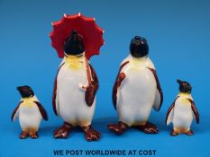 Four Beswick penguins including one with an umbrella