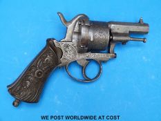 A six shot hammer action pin fire revolver with heavy engraving to the cylinder side plate and 2.
