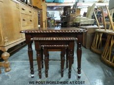 A modern mahogany nest of tables raised on turned and reeded supports (width 59cm)