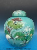A Chinese ginger jar and cover with relief moulded decoration of a stork and lily pads (24cm tall)