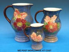 Three graduated Royal Doulton hand-painted jugs with wild rose design (heights 22cm, 19cm, 12.