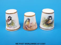 Three Royal Worcester thimbles hand decorated with birds, two signed Barber, the other Stinton,