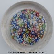 Probably John Walsh Walsh close-pack millefiori glass paperweight of footed form with various