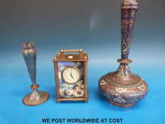 A small carriage clock decorated with classical scenes and two middle eastern cloisonné vases