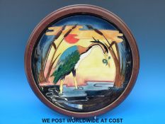 A large, wood framed Moorcroft charger decorated with a heron fishing (38.