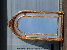 A large ornate gilt framed mirror with arched top,