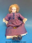 A Continental bisque headed doll with closed mouth, fixed blue eyes and blonde hair in period dress,