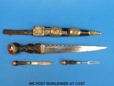 A Scottish regimental dirk with fullered blade in leather scabbard with metal mounts.
