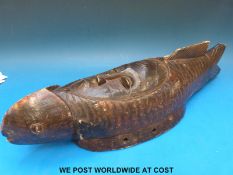 An African mask depicting a face incorporated into a fish body,
