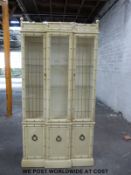 A bamboo effect break front display cabinet with cupboards below (W102 x D39 x H204cm),