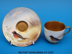 A Royal Worcester cup and saucer hand decorated with a red capped robin,