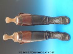 A pair of vintage black leather riding or hunting boots with brown top bands,